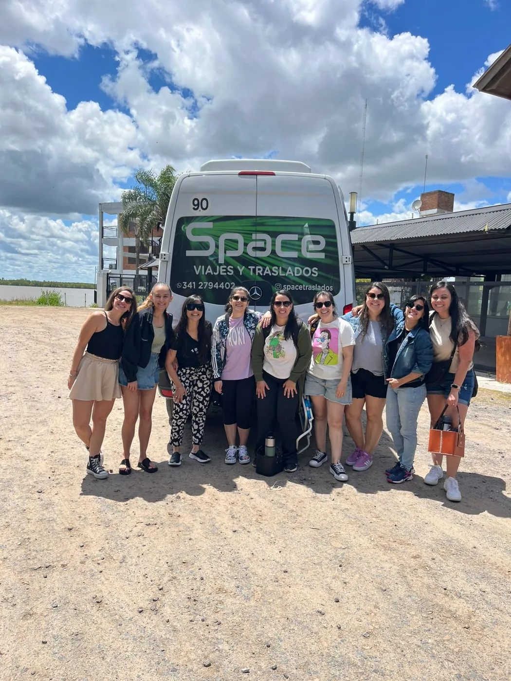 Grupo de pasajeras frente a la combi de Space